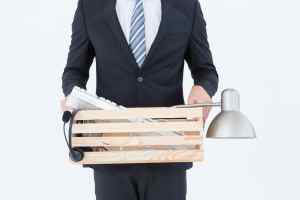 Businessman holding box of his things on white background