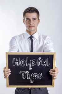 Helpful Tips - Young businessman holding chalkboard with text
